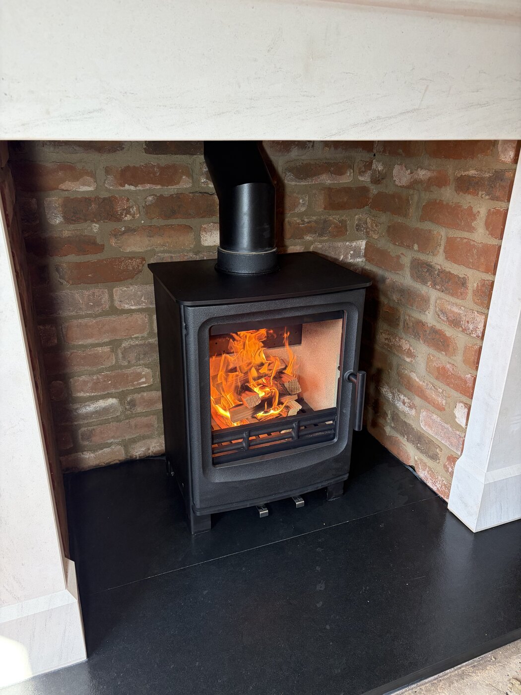 Close view of a lit wood-burning stove installation